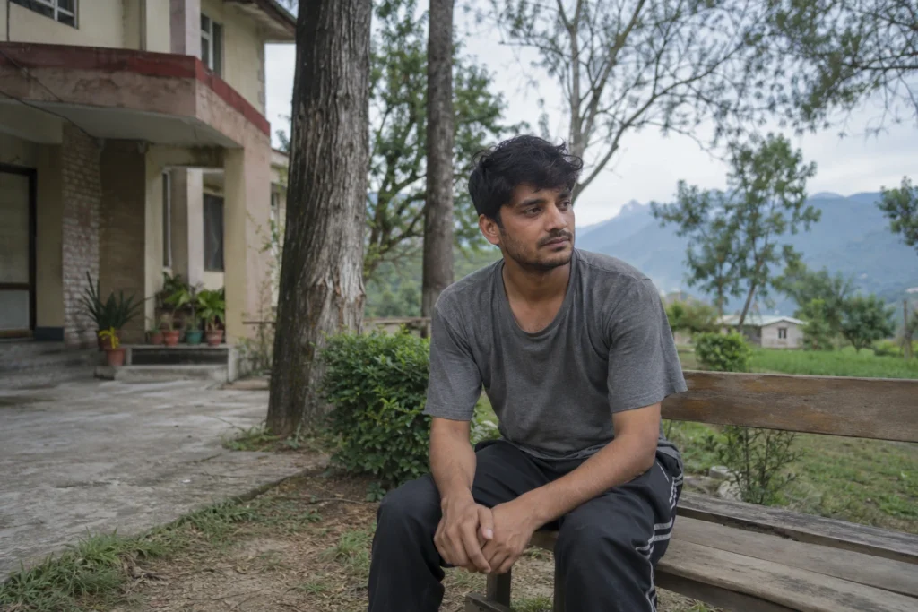 Young man sitting outdoors at a rehabilitation centre in Kangra, Himachal Pradesh